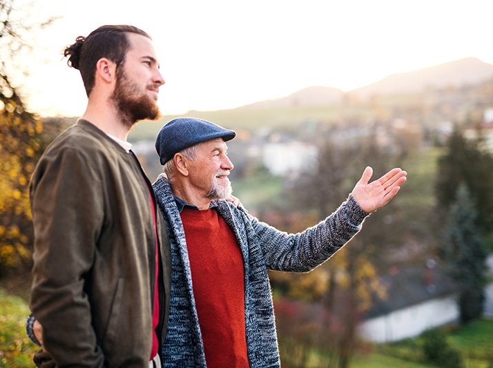 Senior father and his son on walk in nature, talking.