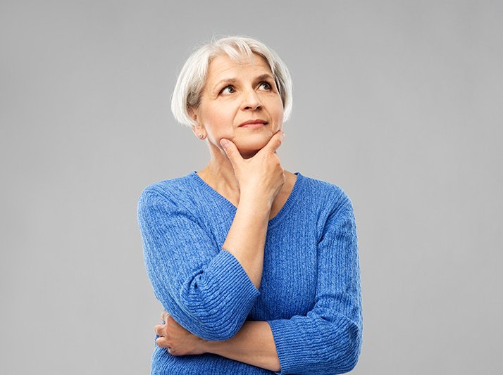 portrait of senior woman in blue sweater thinking